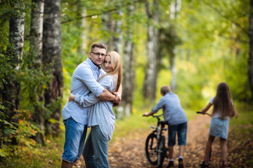 Fototapeta premium Family Group Standing Outdoors At Green Park In Autumn Landscape