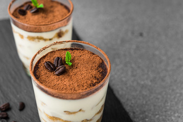Close up of a traditional Italian tiramisu cake sweet dessert on grey and black background