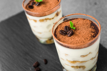 Close up of a traditional Italian tiramisu cake sweet dessert on grey and black background