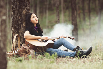 Asia woman playing the guitar with loneliness and sadness.heartbroken woman concept.