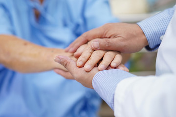Holding Touching hands Asian senior or elderly old lady woman patient with love, care, helping, encourage and empathy at nursing hospital ward : healthy strong medical concept .