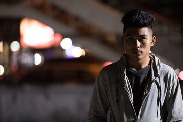 Young Asian man in the city streets at night