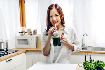 Healthy woman enjoy making green vegetables detox cleanse and green fruit smoothie with blender in kitchen at home.dieting concept.healthy lifestyle