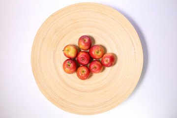 Small mini red apple on wooden plate