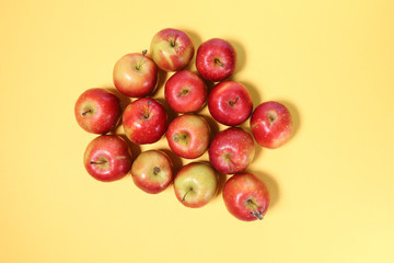 Small mini red apple on yellow background