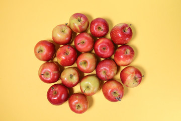 Small mini red apple on yellow background