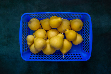 Still life with pear-shaped yellow decorative pumpkins in a blue box