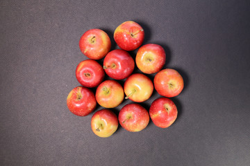 Small mini red apple on black background