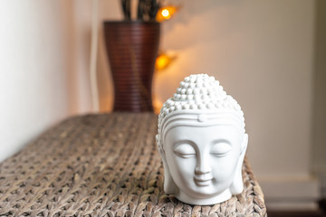 Miniature white buddha head & face. Illuminated background. Home decoration ornaments.