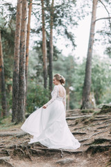 Obraz na płótnie Canvas Elegant ceremony in European style. Beautiful bride in white flying dress in the forest.