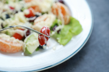 fork picking tomato from salad fruit for eating 