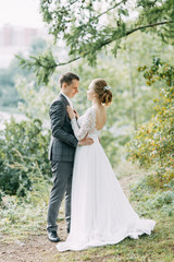 Modern ceremony in European style. Beautiful wedding couple in atmospheric forest with rocks.
