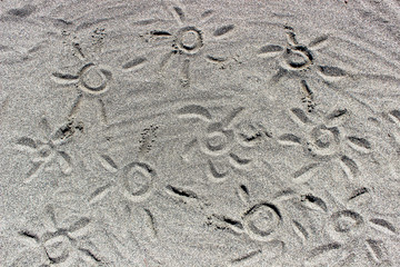 In the sand painted suns. Background of sand.