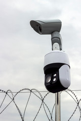 Security camera against a cloudy, stormy sky.