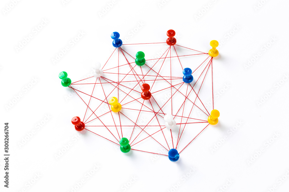 Wall mural network with colorful pins and string, linked together with string on a white background suggesting 