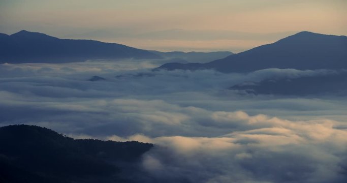 Scene time lapse of misty over at mountain with misty clouds fast movement, Nature of sunrise background