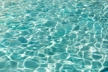 Turquoise blue water in swimming pool background, sun reflection, clear clean water, shining water...