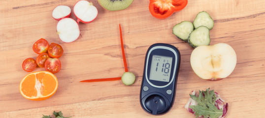 Glucometer with clock made of fruits and vegetables, healthy eating for diabetics concept