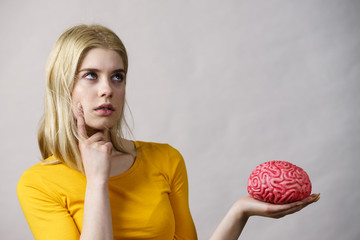 Woman thinking holds brain