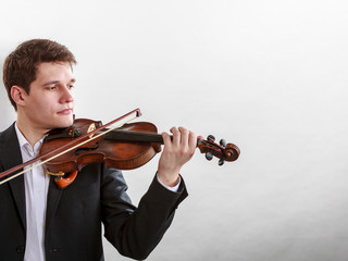 Man man dressed elegantly playing violin