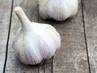 Organic garlic bulbs on a wooden table in the background.