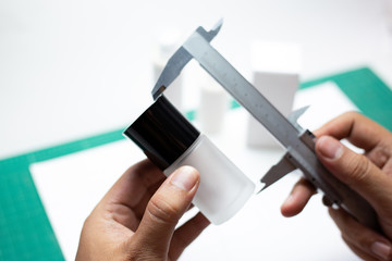 Hand holding vernier caliper to measure the size of the cosmetics container. Product cosmetic...