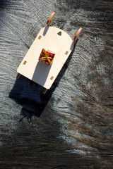Christmas wood toys sled with gift boxes on old wood wooden table with snow.