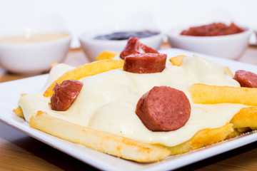 Colombian salchipapa with cheese and sauces