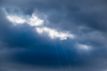Fototapeta premium Dramatic sky with sunbeams through the clouds