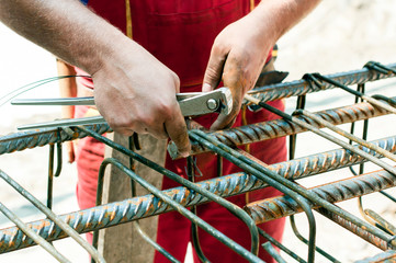 Construction worker ties reinforcing steel