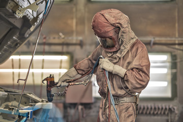 employee body painting workshop carries out painting of the internal elements of the car.