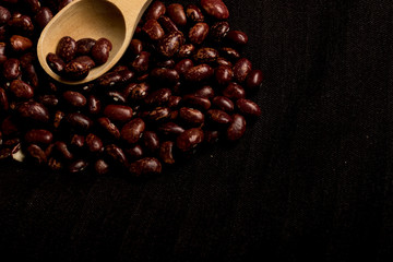 beans and spoon on dark background