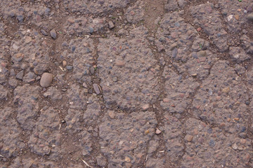 Cracked old asphalt for background. Stones, dust, earth, cracks.