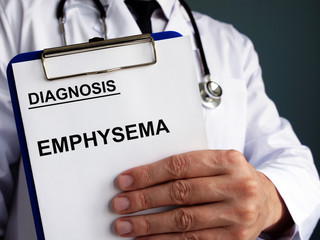 Diagnosis Emphysema with clipboard holds by doctor.