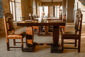 Glasses, flower fork, knife served for dinner in restaurant with cozy interior