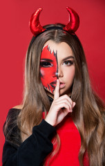 Devil. Funny imp with red horns and black bow tie at Halloween party. Halloween makeup. The devil costume.