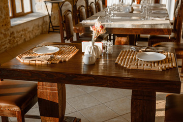 Glasses, flower fork, knife served for dinner in restaurant with cozy interior