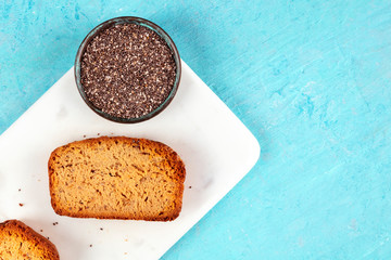 Chia seed cake, shot from the top on a marble cutting board and a blue background with a place for...