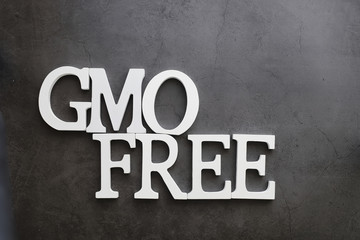 The concept of proper and environmental health. The inscription on black background with wooden letters and paper elements. Free GMO. Zero waste.