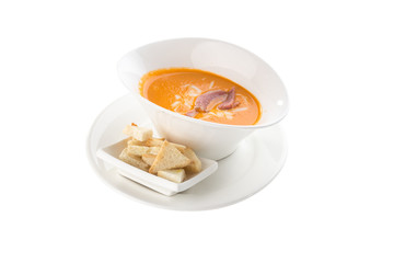 Pea soup with smoked ribs and bread croutons in white bowl isolated on white background