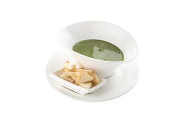 bowl of broccoli and green peas cream soup with bread croutons isolated on white background