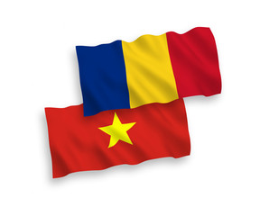 National vector fabric wave flags of Romania and Vietnam isolated on white background. 1 to 2 proportion.