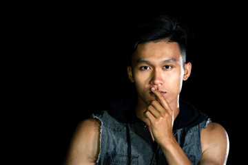 Portrait of young serious handsome boy with muscle on the black background