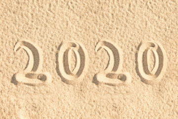 Year 2020 written in the sand of a beach, new year card