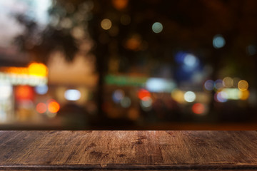 Empty dark wooden table in front of abstract blurred bokeh background of restaurant . can be used for display or montage your products.Mock up for space.
