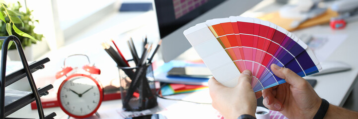 Male serviceman hold in hand fantail making colour test at worktable