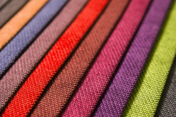 Colorful and bright fabric samples of furniture and clothing upholstery. Close-up of a palette of textile abstract stripes of different colors