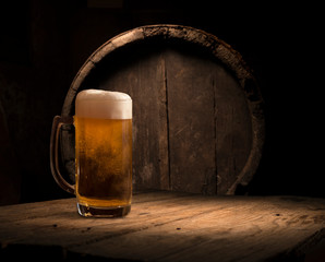 Oktoberfest beer barrel and beer glasses with wheat and hops on wooden table