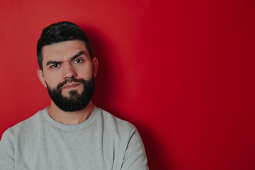 Bearded man on the red background. Sexy bearded man.
