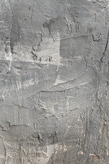 The texture of gypsum or alibaster cracked plaster on the wall is a thick layer. Gradient gray...